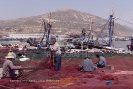 Image du Maroc Professionnelle de  Quelques ouvriers s'activent à réparer les filets de pêche sur un des quais au port d'Agadir, ville située au sud du Maroc, Vendredi 23 Août 2002. (Photo / Abdeljalil Bounhar)

 